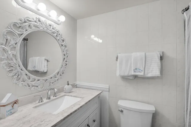 a bathroom with a granite countertop toilet sink and mirror