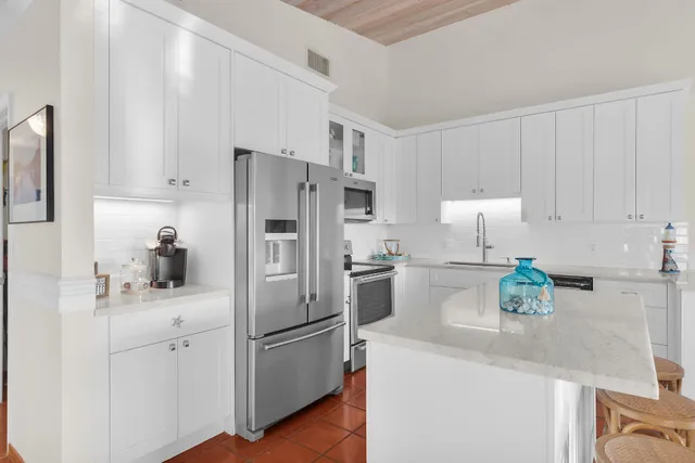 a kitchen with stainless steel appliances a refrigerator sink and white cabinets