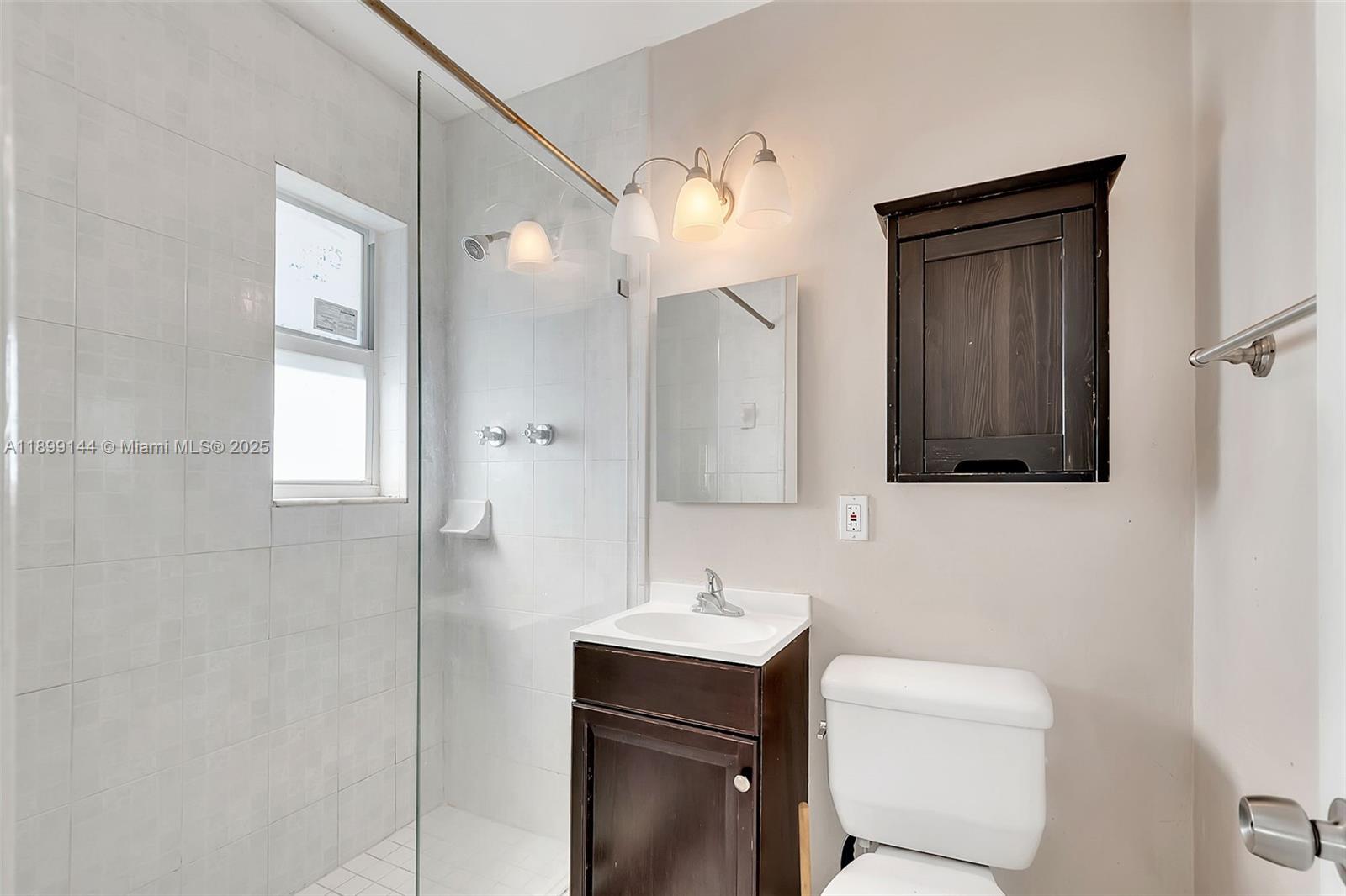 6310 Southwest 79th Street, Unit 19 South Miami, FL 33143 - Photo 3 of 8 a bathroom with a toilet sink shower and mirror