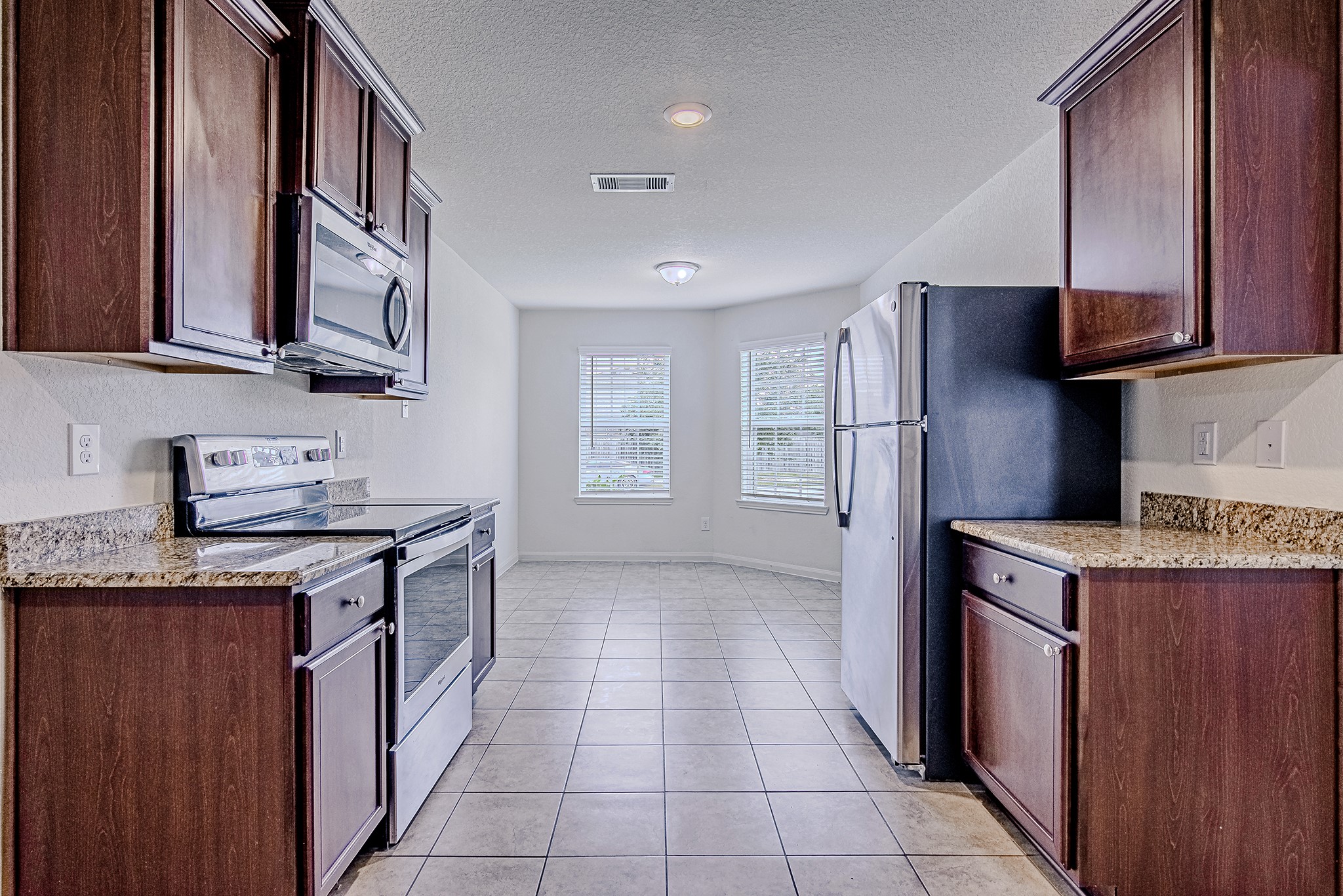 9522 Olive Stone Drive Rosharon, TX 77583 - Photo 13 of 29 a kitchen with stainless steel appliances granite countertop a stove a sink and a refrigerator