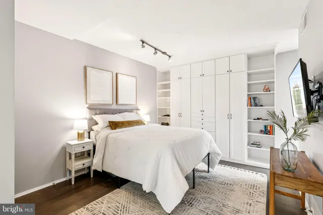 a bedroom with a bed flat screen tv and a fireplace