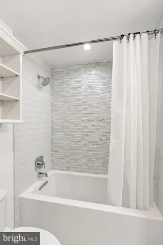 a bathroom with a shower and a bath tub