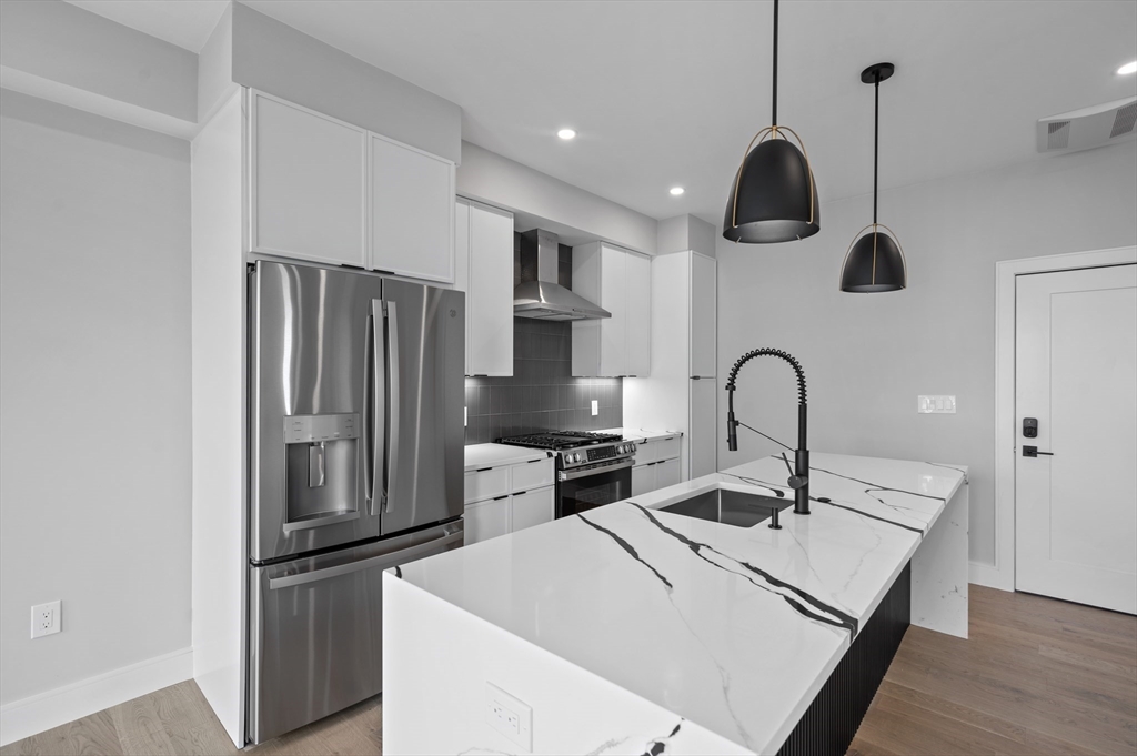 a kitchen with stainless steel appliances a refrigerator sink and stove