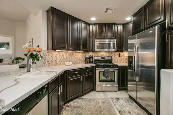a kitchen with kitchen island granite countertop stainless steel appliances and sink