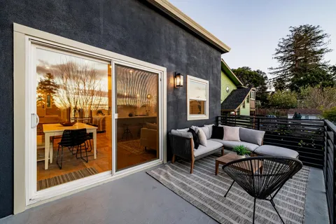 a view of a roof deck with couches and sky view