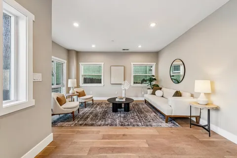 a living room with furniture chandelier and a window