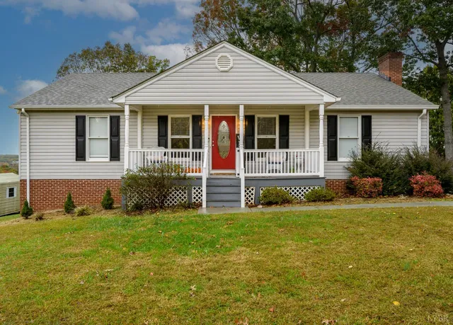 a view of a house with a yard and porch