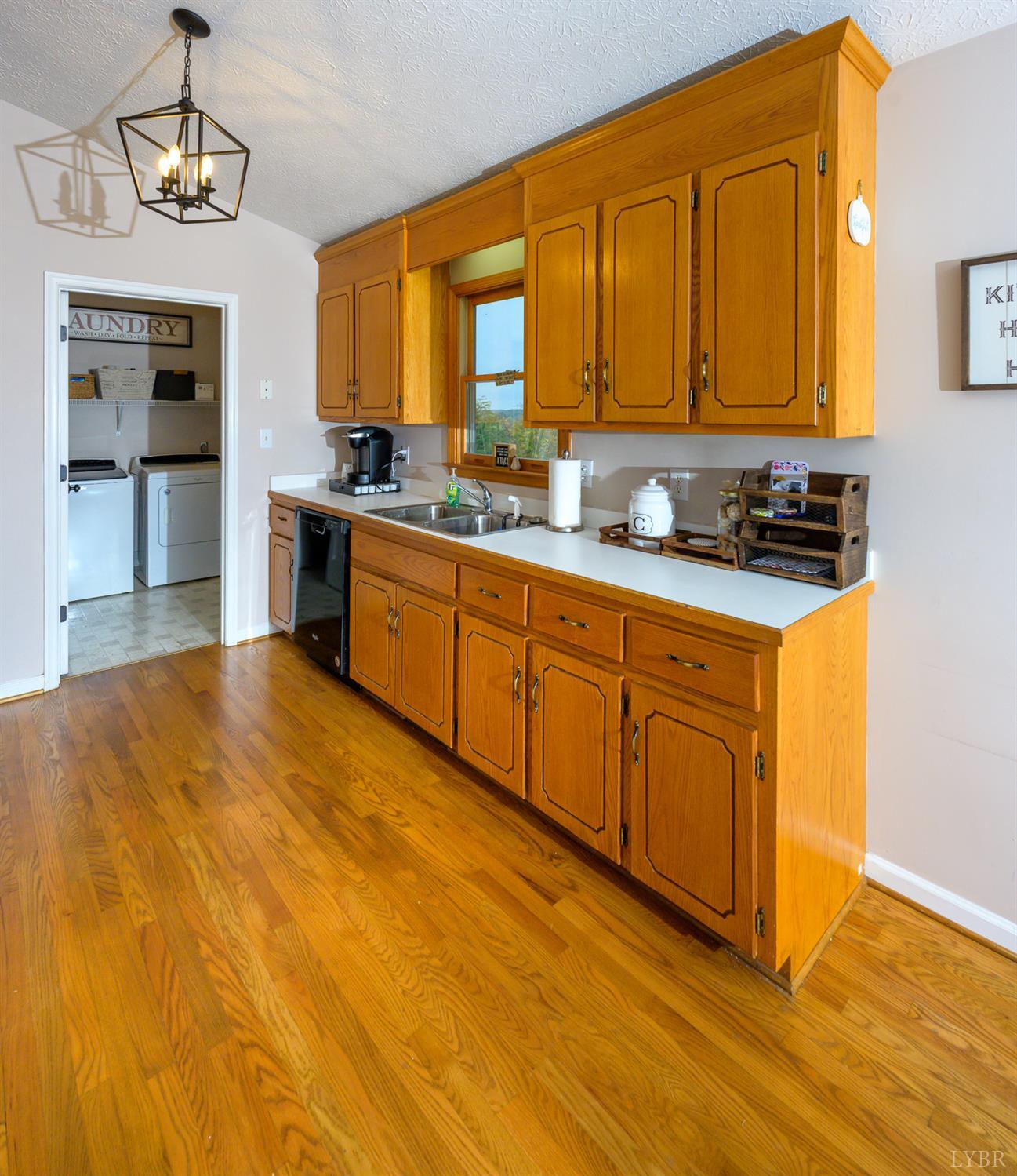 151 Wilderness Road Rustburg, VA 24588 - Photo 6 of 63 a large kitchen with stainless steel appliances granite countertop a stove a sink dishwasher a microwave oven with cabinets and wooden floor