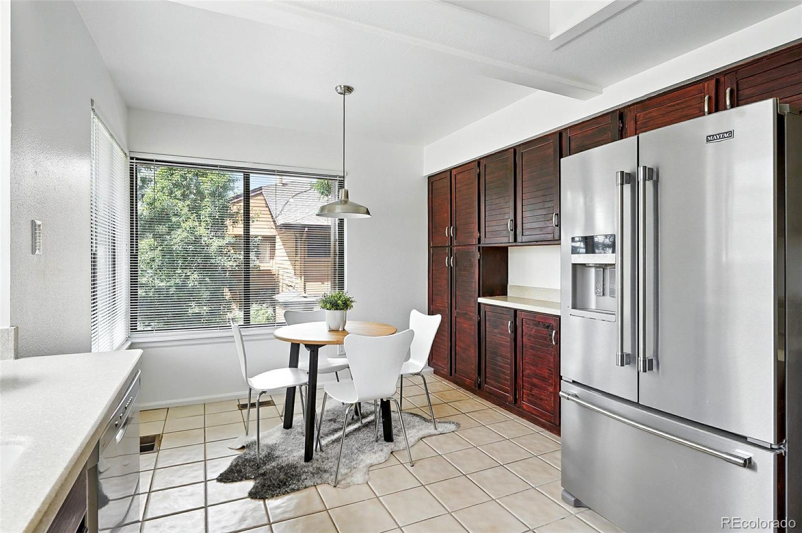 9400 East Iliff Avenue, Unit 321 Denver, CO 80231 - Photo 14 of 44 a kitchen with stainless steel appliances a refrigerator a table and chairs