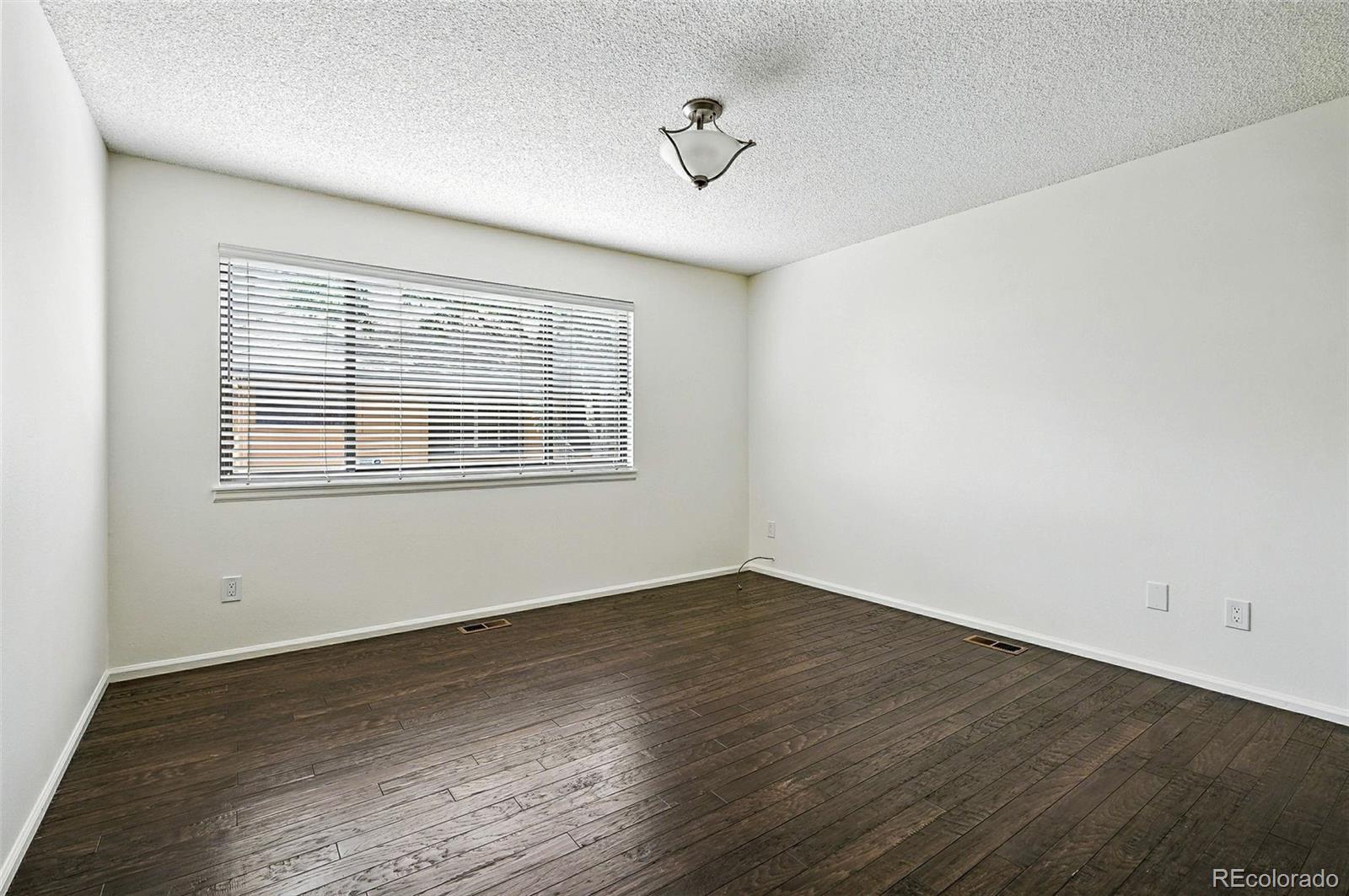9400 East Iliff Avenue, Unit 321 Denver, CO 80231 - Photo 16 of 44 a view of an empty room with wooden floor and a window