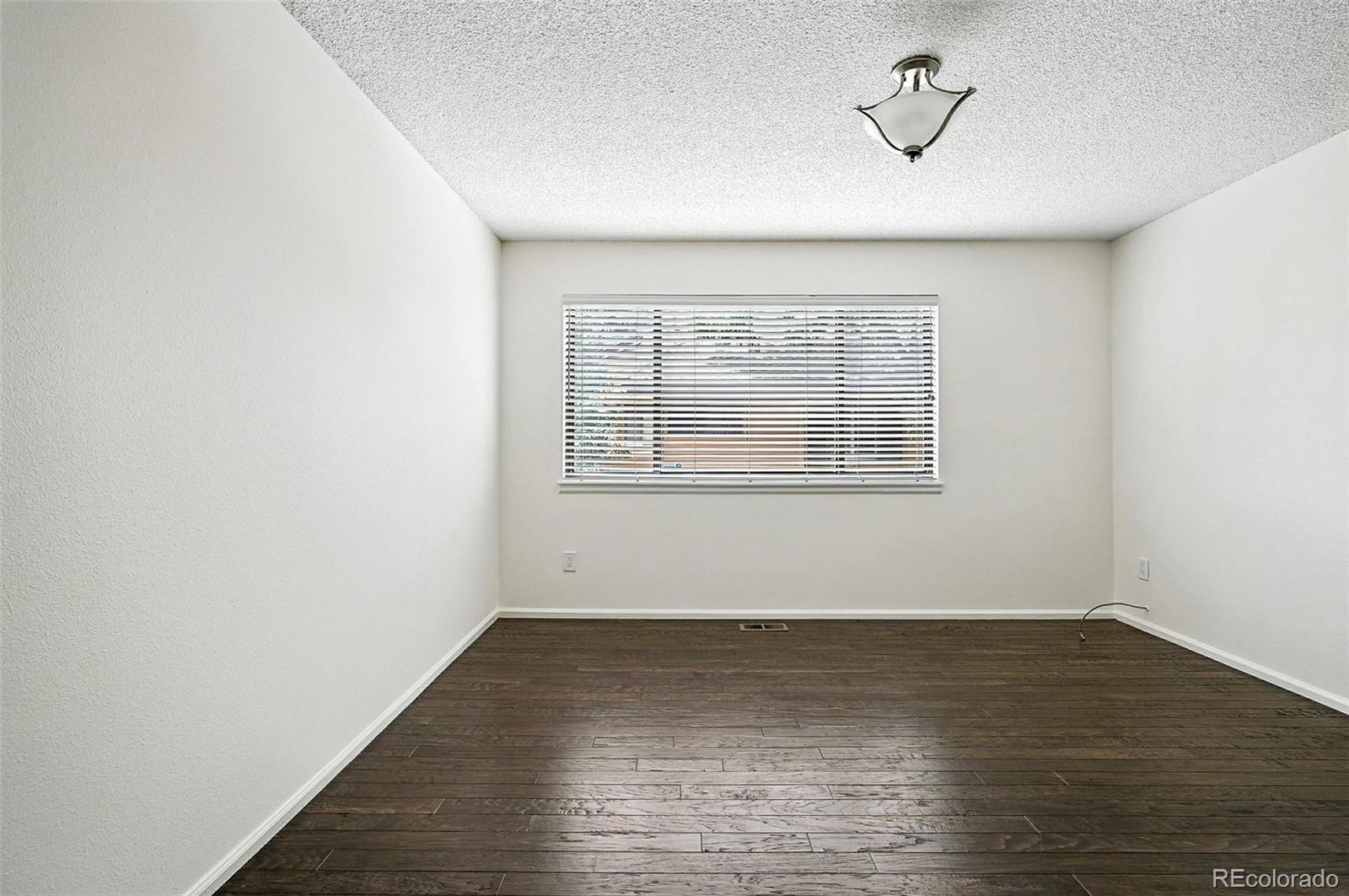 9400 East Iliff Avenue, Unit 321 Denver, CO 80231 - Photo 17 of 44 an empty room with wooden floor and windows