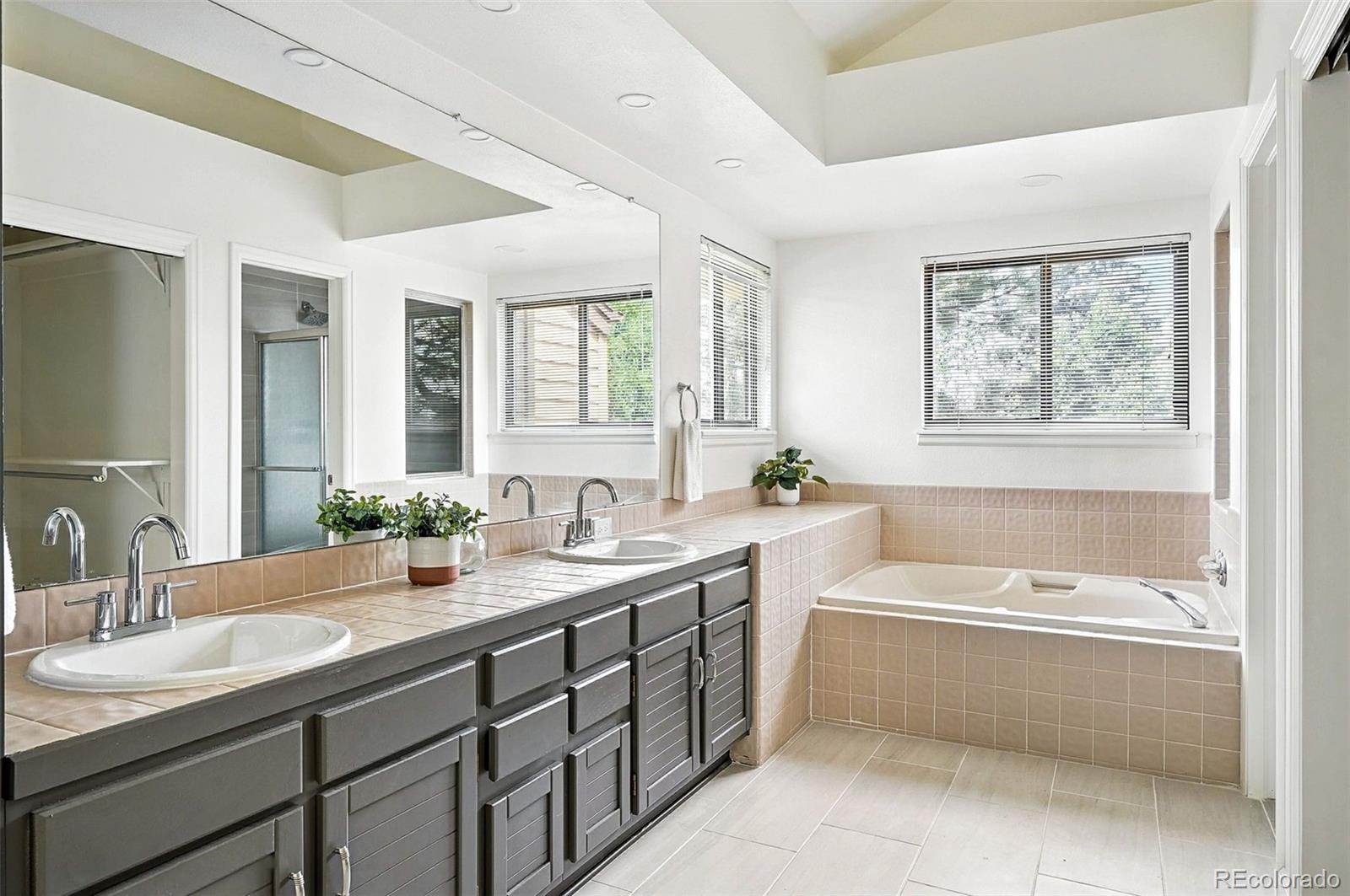9400 East Iliff Avenue, Unit 321 Denver, CO 80231 - Photo 25 of 44 a bathroom with a tub double sink window and mirror