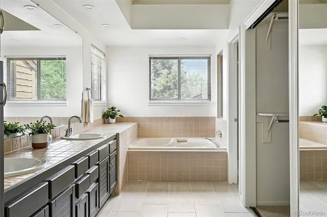 a bathroom with a tub a sink and a window