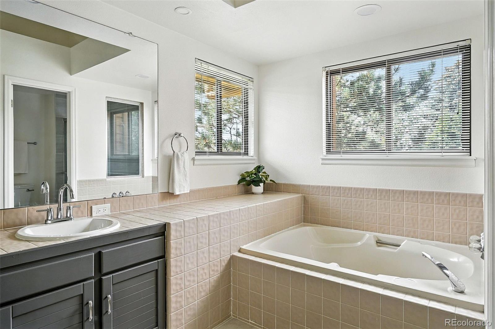 9400 East Iliff Avenue, Unit 321 Denver, CO 80231 - Photo 27 of 44 a bathroom with a tub a sink and a window