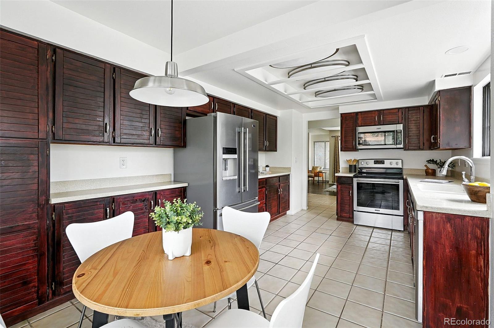 9400 East Iliff Avenue, Unit 321 Denver, CO 80231 - Photo 10 of 44 a kitchen with stainless steel appliances granite countertop a sink a microwave refrigerator and chairs