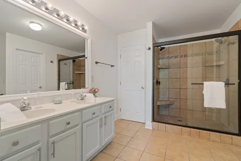 a spacious bathroom with a shower sink and mirror