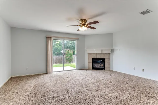 a view of an empty room with a fireplace and a window