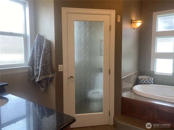 a bathroom with a granite countertop sink a mirror and shower