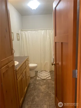a bathroom with a granite countertop sink toilet and a mirror