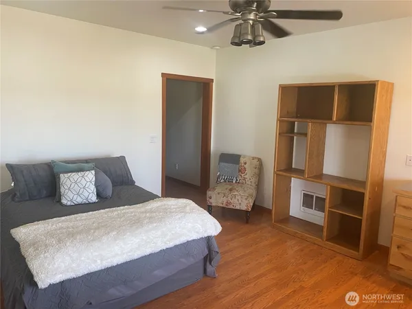 a spacious bedroom with a bed and a ceiling fan