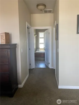 a view of a hallway with furniture