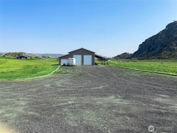 a view of a big house with a big yard and large trees