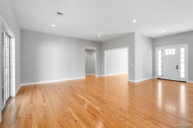 a view of a kitchen with a refrigerator a stove top oven a counter space and wooden floor