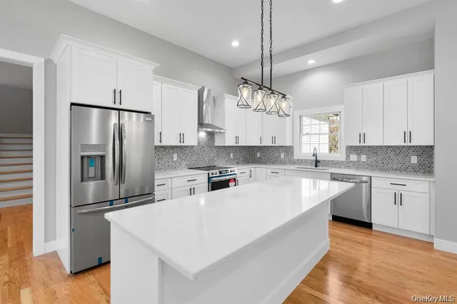 a large kitchen with cabinets a sink and stainless steel appliances