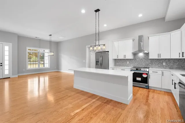 a large kitchen with stainless steel appliances granite countertop a oven a stove and a wooden floors