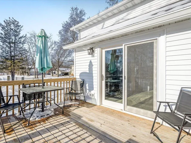 a balcony with table and chairs and potted plants