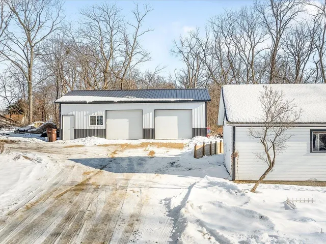 a view of a white house with snow on the road