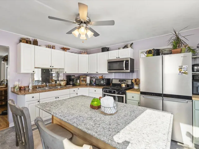 a kitchen with stainless steel appliances granite countertop a sink a stove and cabinets