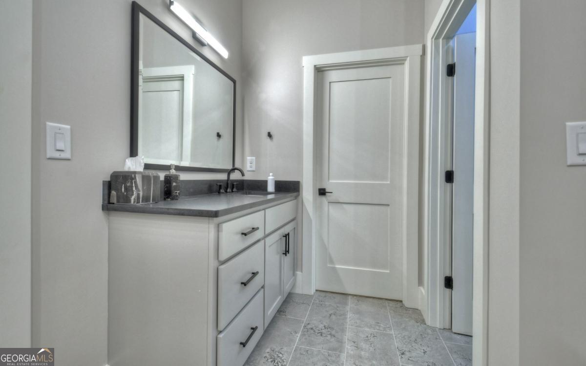 375 Blue Berry Ridge, Unit 2B Morganton, GA 30560 - Photo 28 of 61 a bathroom with a granite countertop sink and a mirror