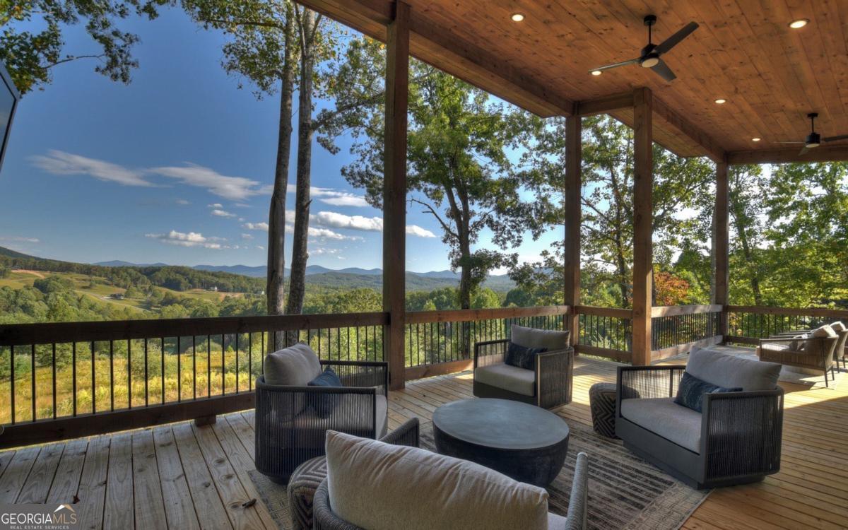 375 Blue Berry Ridge, Unit 2B Morganton, GA 30560 - Photo 36 of 61 a view of a patio with couches table and chairs and wooden floor