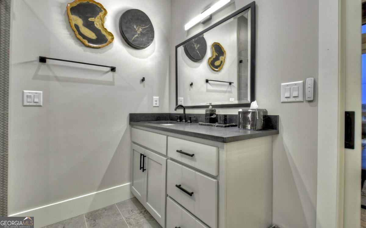 375 Blue Berry Ridge, Unit 2B Morganton, GA 30560 - Photo 60 of 61 a bathroom with a granite countertop sink and a mirror