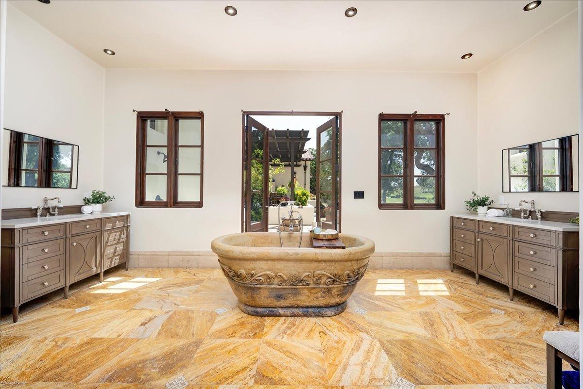 217 Rue Esperanza Lincoln, CA 95648 - Photo 25 of 71 Primary bathroom with french door to secondary outdoor shower. Solid stone tub with Perrin and Rowe fixtures. New vanities in 2025.