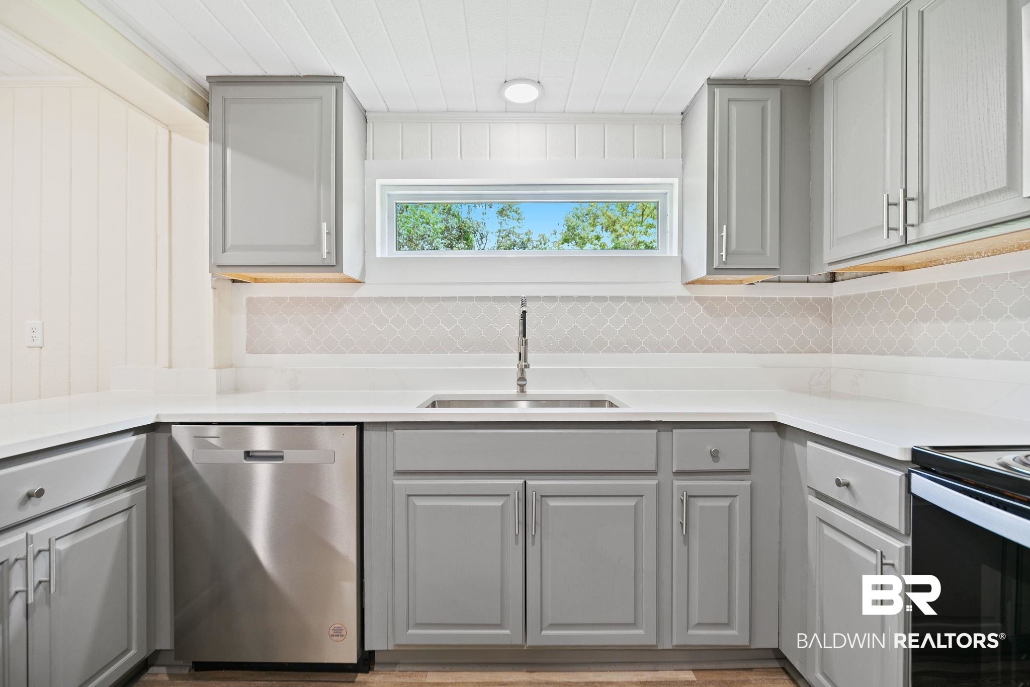 507 Byrne Street Bay Minette, AL 36507 - Photo 10 of 40 Kitchen with gray cabinets, sink, dishwasher, and decorative backsplash