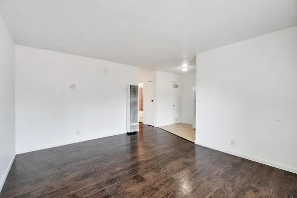 a view of an empty room with wooden floor