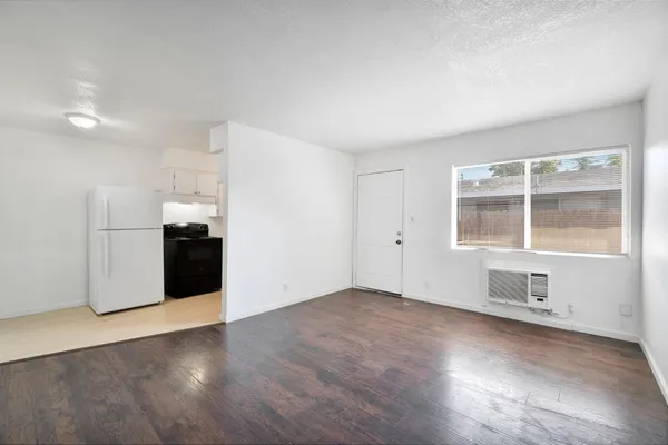 an empty room with wooden floor and cabinet