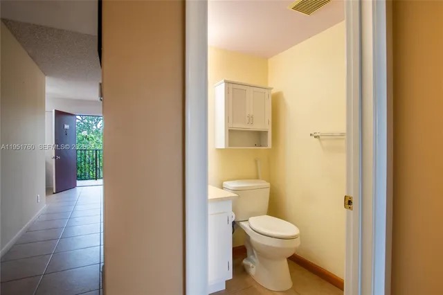 a bathroom with a granite countertop sink mirror vanity and toilet