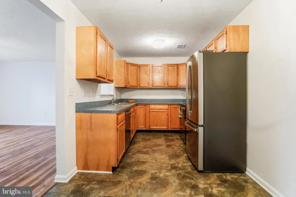 a kitchen with stainless steel appliances granite countertop a refrigerator sink and cabinets