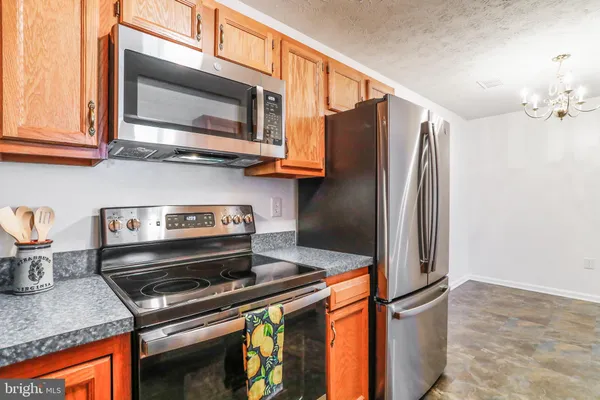 a kitchen with stainless steel appliances granite countertop a stove microwave and refrigerator