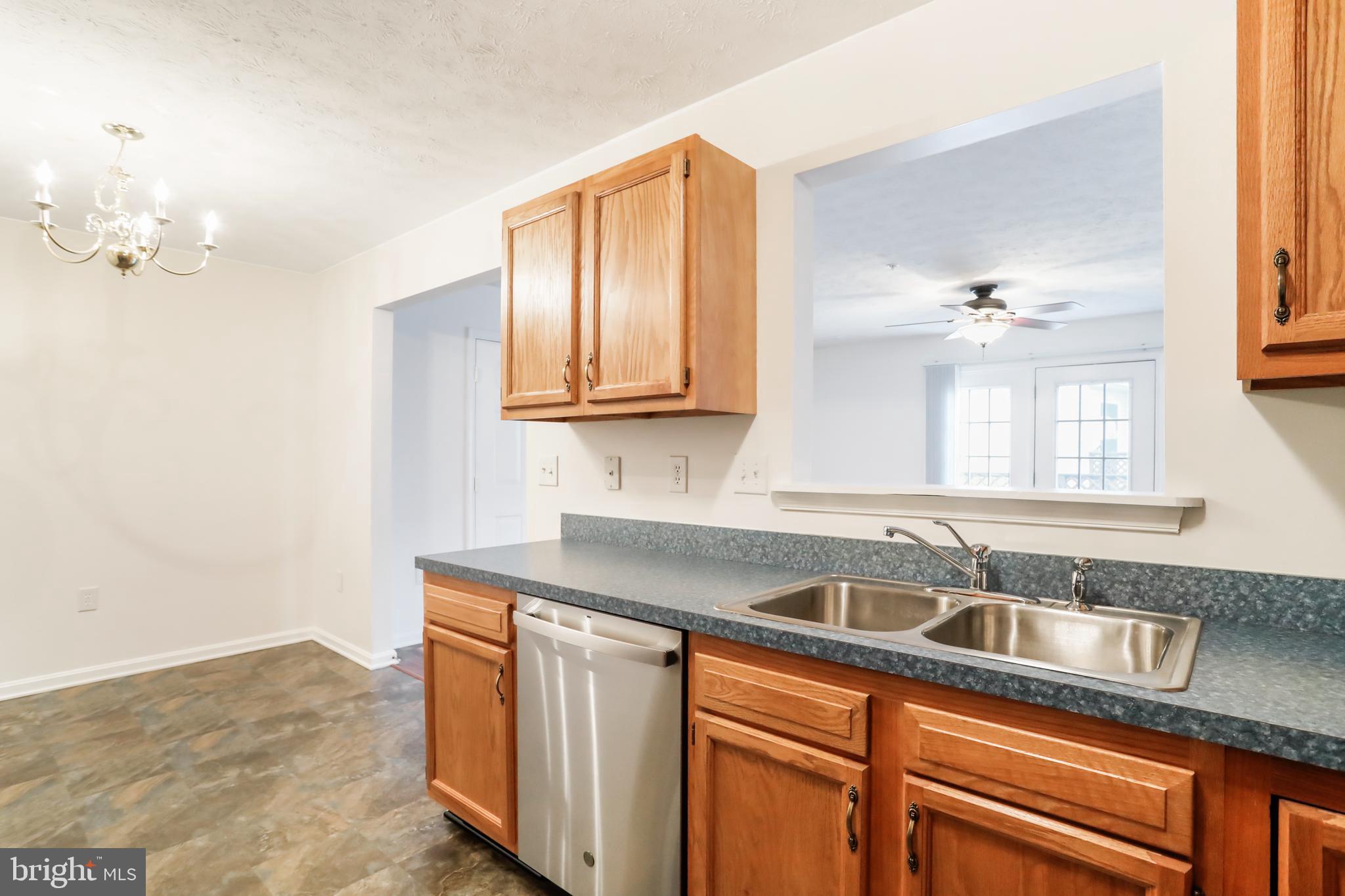 145 Hailey Lane, Unit F11 Strasburg, VA 22657 - Photo 17 of 39 a kitchen with stainless steel appliances granite countertop a sink dishwasher a stove and a microwave oven with white cabinets