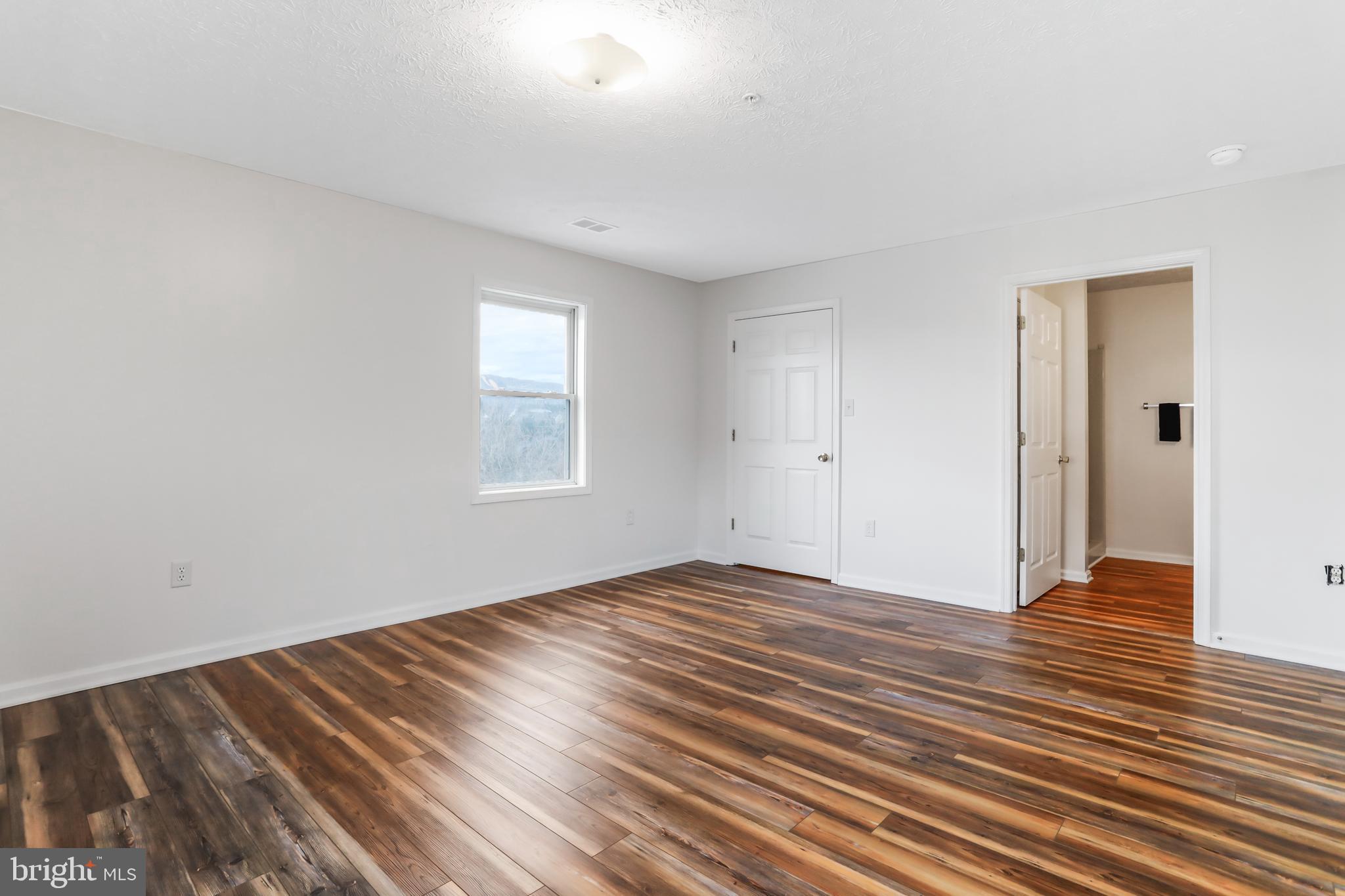 145 Hailey Lane, Unit F11 Strasburg, VA 22657 - Photo 21 of 39 an empty room with wooden floor and windows