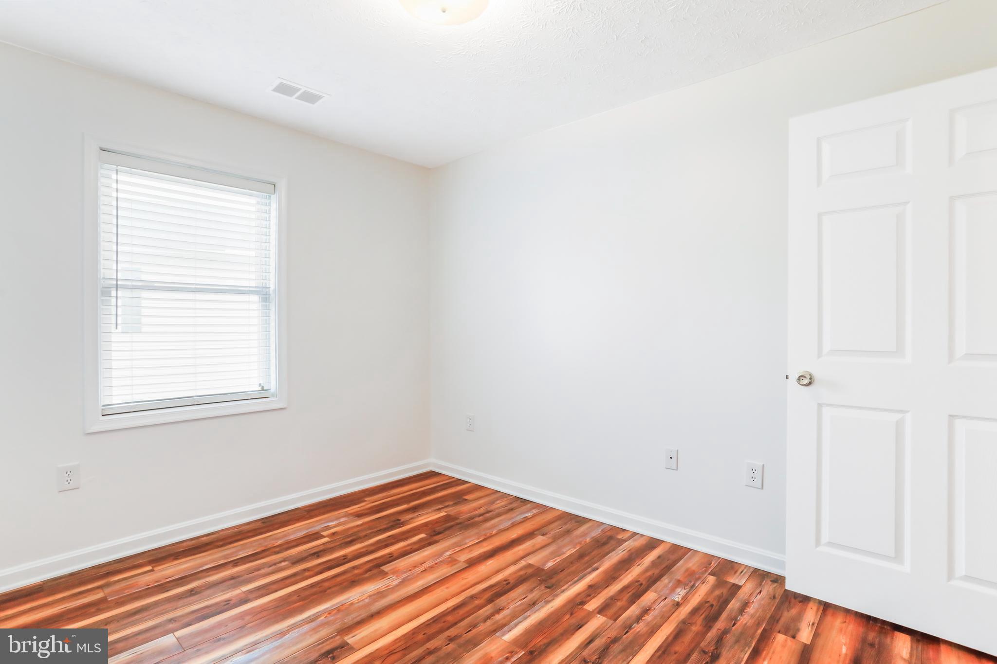 145 Hailey Lane, Unit F11 Strasburg, VA 22657 - Photo 31 of 39 an empty room with wooden floor and windows