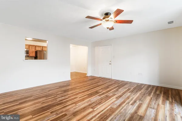 a view of a room with wooden floor and fan