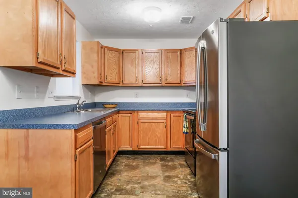 a kitchen with stainless steel appliances granite countertop a refrigerator a sink and dishwasher with a dishwasher