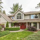 a front view of a house with a yard and potted plants