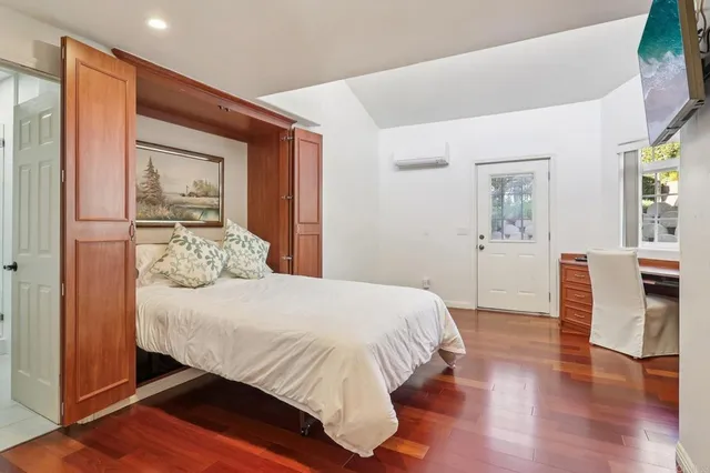 a bedroom with a large bed and wooden floor