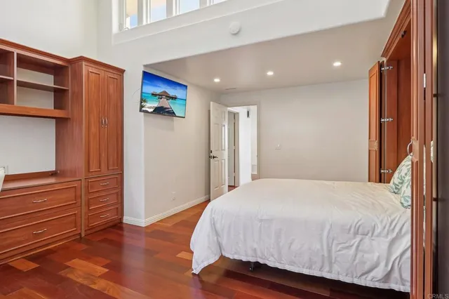 a bedroom with a bed and wooden floor